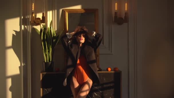 오렌지 Bodysuit와 남자의 재킷에 머리와 테이블에 그녀의 머리를 만지고 그녀의 — 비디오