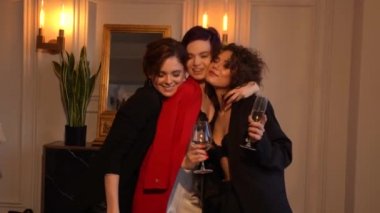 Üç güzel kadın siyah giyimli ve kırmızı ceket ve sütyen yan yana gözlük içecekler, gülüyor, sarılma, konuşurken, tatil partisi veya bachelorette parti holding ayakta durmak