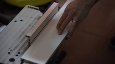 Bir adamın elini bir daire testere ile bir beyaz tahta testereleri