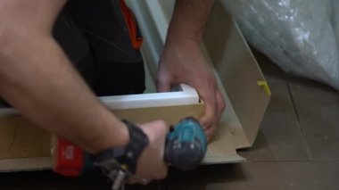 Adam/iş/adam bir matkap kullanarak yapmak iki delik ahşap bir yönetim kurulu