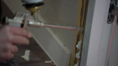 Köpük montaj, püskürtme için bir cihaz holding erkekler eller kapı boşluğu kapat