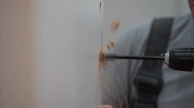 Bir adam bir delik bir delik Beyaz ahşap tahta/kapıya yakın çekim matkap kullanarak yapar