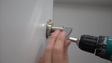 Kapı kolu ile vida ve bir tornavida, yakın çekim için bir erkek eli ekler