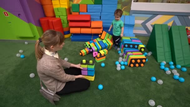 Mamá Sienta Suelo Sala Juegos Construye Una Torre Con Hijo — Vídeos de Stock