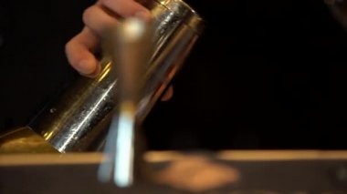 Yakın çekim: barmen bir kapsayıcı sıvıdan shaker dökülen, o kapatmak, titremeye başlar