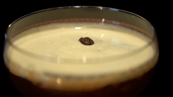 カクテルをグラスに飲み物ピンセットを入れてターンで つのコーヒー豆があり クローズ アップ マクロ — ストック動画