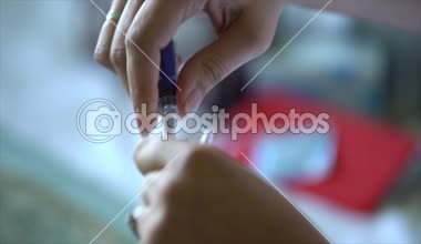 Kadın elleri açık bir ilaç ampulünden tıbbi bir şırıngayla alınır, içindeki havayı boşaltır, hemşire aşı için aşıyı hazırlar.