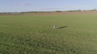 Mavi gömlekli ve kot pantolonlu bir adam mavi elbiseli bir kızın elini tutar, sahaya çıkarlar, Güneşli bir yaz gününde hava fotoğrafçılığı yaparlar, kamera birkaç sevgiliden uzaklaşır.