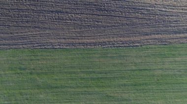 Hava fotoğrafçılığı: yeşil açık alan ve siyah sürülmüş zemin, aralarında net sınır, üst noktadan çekim, kamera yavaş yukarı yükselir