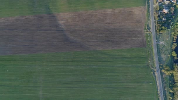 航空摄影 绿色开阔的田野和黑色的耕田 汽车行驶的高速公路 夏日日落时 相机慢慢接近地面 — 图库视频影像