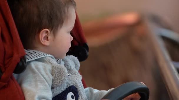 Sitzt Ein Kleines Kind Junge Einem Dunkelroten Kinderwagen Schaut Weg — Stockvideo