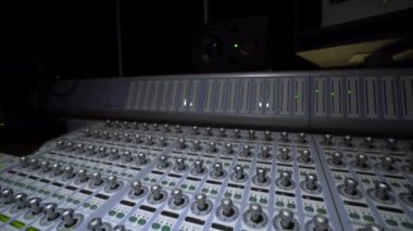 Kayıt Studio büyük bir çok kanallı karıştırma konsolu, kamera nesne, klavye ve ses mühendisi eli uzak hareket çerçeve görünür