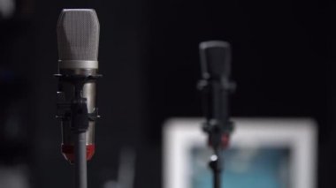 Siyah arka planda gri mikrofon, yukarı. Arka planda siyah bir mikrofon görünür. Kayıt Stüdyosu/karaoke/konser