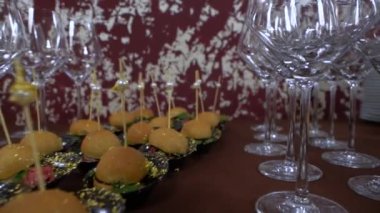 Büfe masası: ahşap şişler ve boş şarap bardakları üzerinde mini burger, yakın çekim
