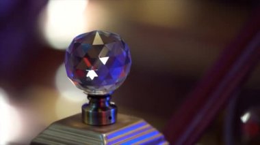 Ahşap bir merdivenin parmaklıklarındaki kristal topuz, yakın çekim, yapay ışık altında bir gece kulübünde çekim