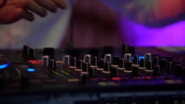 Dj mikser arkasında duruyor, Dj denetleyicisi, müzik karışımları, kolları bükümler, çekim eller yakın çekim, gece kulübü, yapay aydınlatma, ışık müzik mor, sarı, mavi, Gece kulübü parti