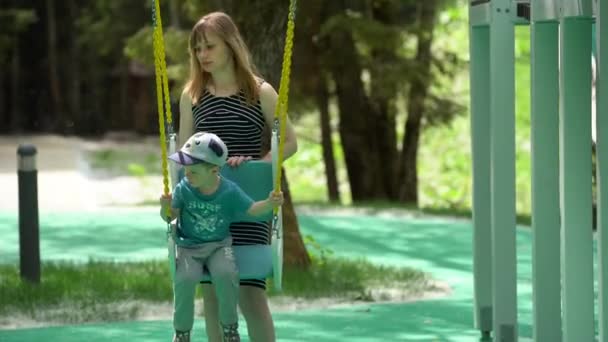 Small Child Boy Sitting Swing Looking Side Child Mother Shakes — Stock Video