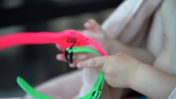 儿童手拿着两个手镯与更衣室钥匙在更衣室粉红色和浅绿色 — 图库视频影像