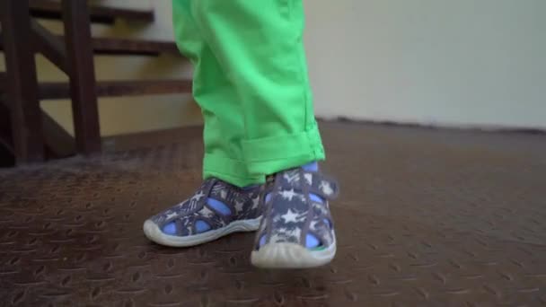 Kinderfüße Grauen Sandalen Blauen Socken Und Hellgrünen Hosen Auf Einem — Stockvideo