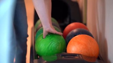 Ball dönüş sistemi çerçevesinde, mavi kot pantolonlu bir kız yeşil bir topu alır ve uzaklaşır, yakın çekim