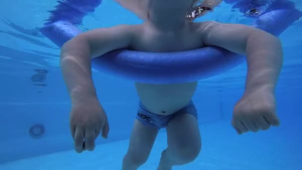 小さな子供 男の子は プールで水中で写真を撮って 入浴のために棒の上に浮かぶ — ストック動画