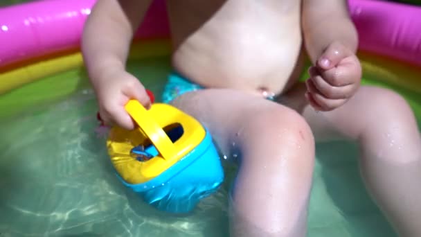 Маленький Хлопчик Сидить Надувному Басейні Водою Набирає Свою Долоню Воду — стокове відео