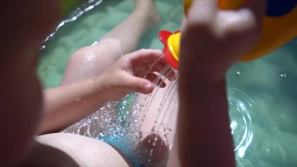 Niño Pequeño Sienta Una Piscina Inflable Agua Vierte Agua Una — Vídeos de Stock