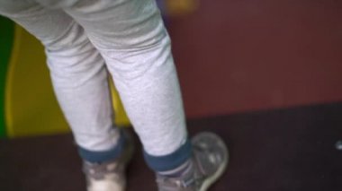 Gri pantolonlu çocuk çocuk çocuk oyun alanında merdiven lere tırmanıyor ,yakın çekim