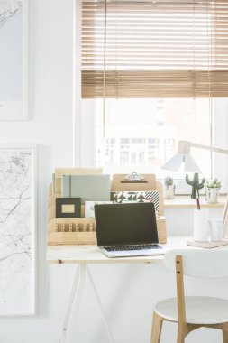 Dizüstü bilgisayar ve ahşap doğal ev ofis iç pencere ile Organizer'da masada beyaz sandalye
