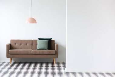 Kahverengi kanepe altında en az oturma odası iç kopya alanı beyaz duvar ile pembe lamba
