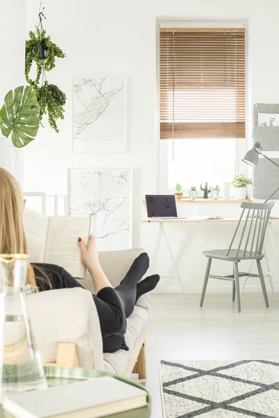 Fille Lisant Livre Tout Allongé Sur Canapé Dans Intérieur Bureau — Photo