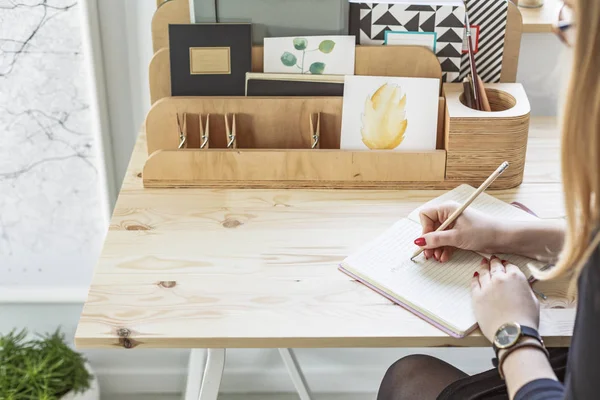 主催者と木製の机に座って鉛筆で日記を書く女の子のクローズ アップ — ストック写真