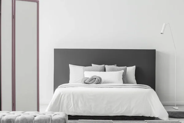 Lámpara Blanca Junto Una Cama Con Cabecera Gris Interior Del — Foto de Stock