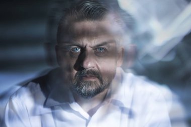 Blurred close-up of a serious man with drug induced hallucinations clipart