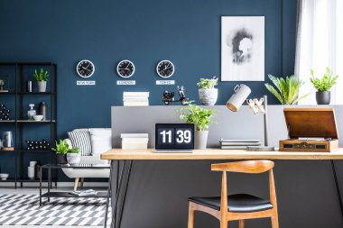 Koyu mavi salon iç siyah endüstriyel raflar ve gri bir yarım duvarla şık çalışma alanı ile