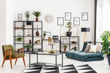 Resepsiyon ve beyaz salon iç katlanmış yatak kanepe, taze bitki ve metal raf içinde laptop ile ev ofis köşe