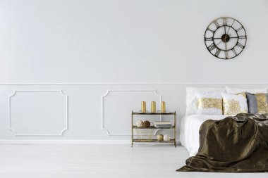 Altın yastık, yatak ve minimalist yatak odası iç kopya alanı ile bir sanayi, metal duvar saati ile büyük yatak