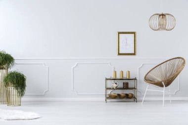 Modern hasır sandalye ve altın çerçeve içinde beyaz boş çizim bir zarif salon iç duvar