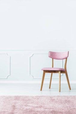 Işık gri odası iç boş duvar ve halı ile ayakta pembe, ahşap sandalye