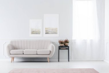 Parlak, minimalist oturma odası iç bej kanepe ayakta yakın pencere ve siyah dışkı ile