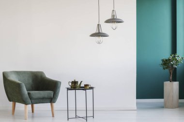 Koltuk, Masa, lambalar ve bitki ayarla çaydanlık ile minimalist oturma odası iç