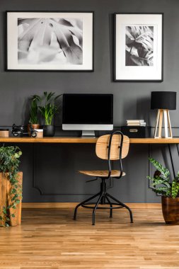 Bir karanlık, ahşap ev ofis iç boş bilgisayar monitör o Resepsiyon ayakta kalıp ile siyah duvara ile gerçek fotoğraf