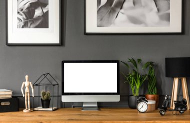 Bitkiler ve çalışma alanı iç saati ile ahşap masa boş bilgisayar monitöründe mockup