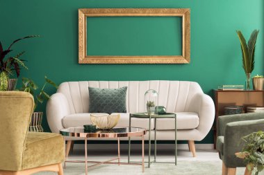 Oturma odası iç parlak kanepe ve boş mockup çerçeve ile yeşil ve altın tablolarında metal