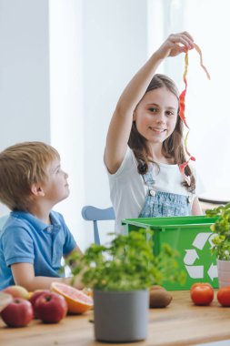 Kız kardeşi ona arıyor iken bir çöp tenekesi içine biyolojik atık atma