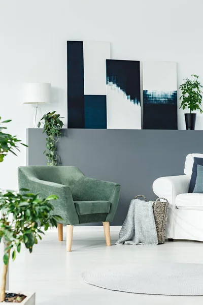 绿色扶手椅站在白色起居室内与新鲜植物和现代艺术绘画 — 图库照片