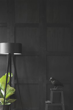 Bir lamba ve bitki en az oturma odası iç yanındaki masada siyah kuş