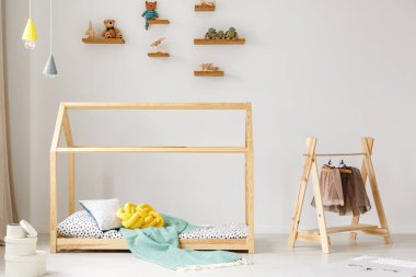 DIY çocuğun yatak odası iç dondurma lambalar ile ahşap bir yatakta yanında bir raf kıyafet