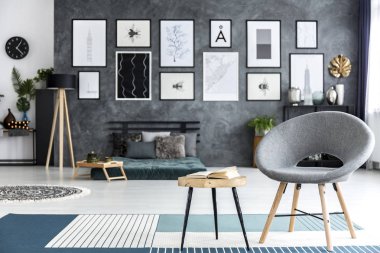 Yatak odası iç mavi halı üzerinde kitap ile ahşap bir masa yanındaki gri tekli Close-up