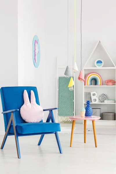 子供の室内で背景にテーブルと白の棚の横にウサギの枕ネイビー ブルー アームチェア — ストック写真